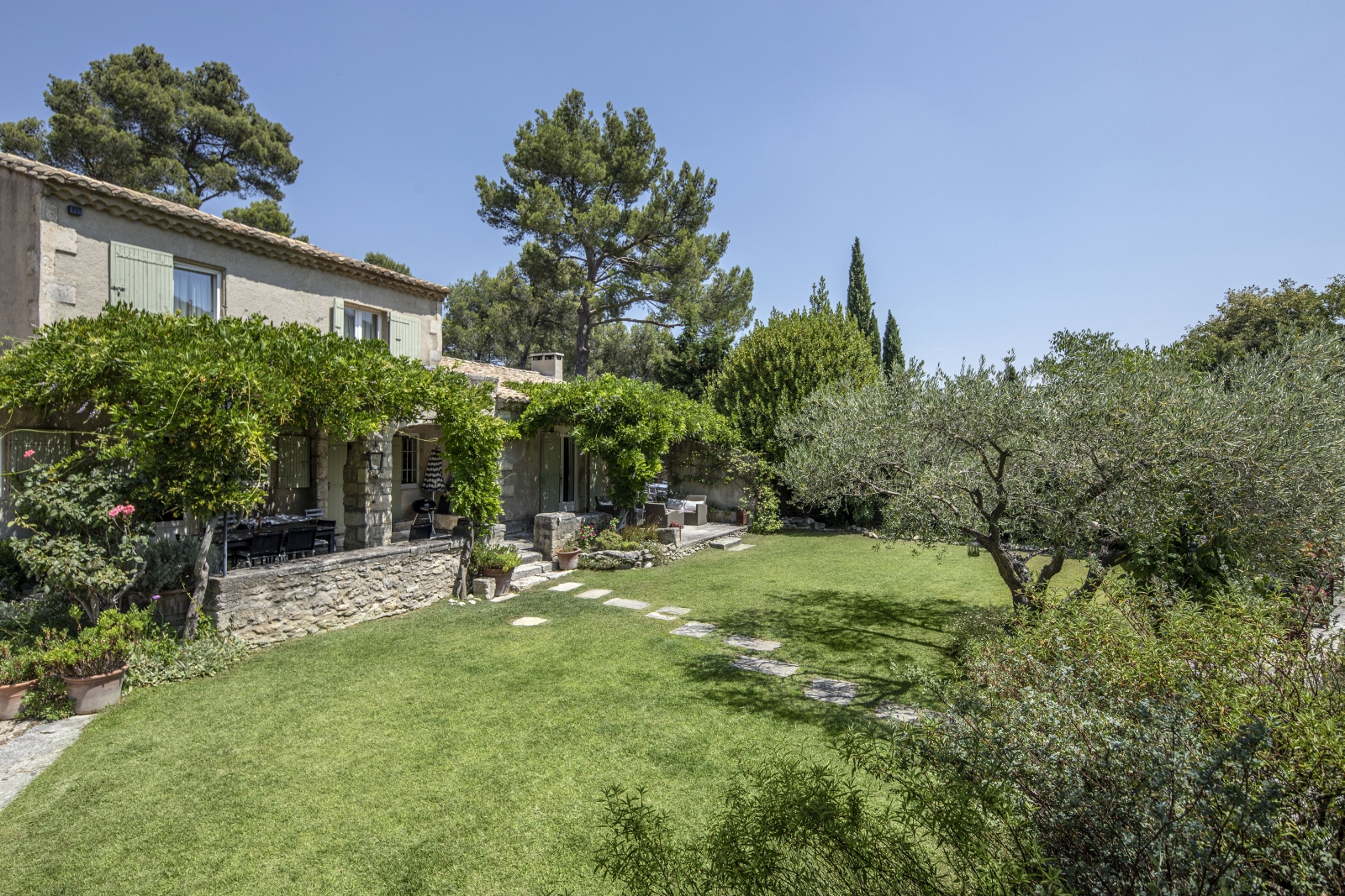 Façade and garden with trees, plants and flowers at Mas Cecile in Provence, France