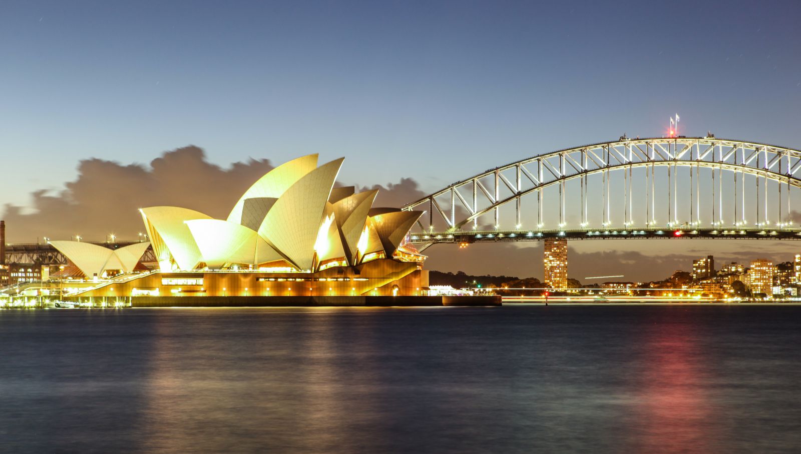 Sun illuminating the sails of the Sydney Opera House and Sydney Harbour Bridge