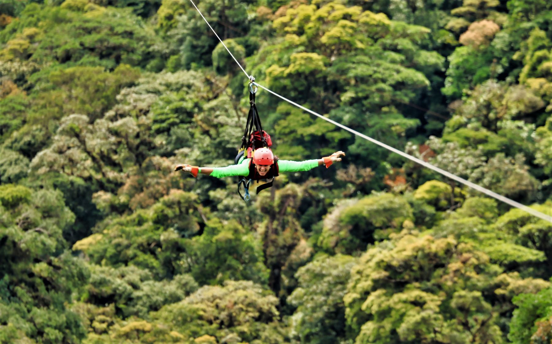 Man trying superman zip line at Selvatura adventure park in Monteverde Costa Rica