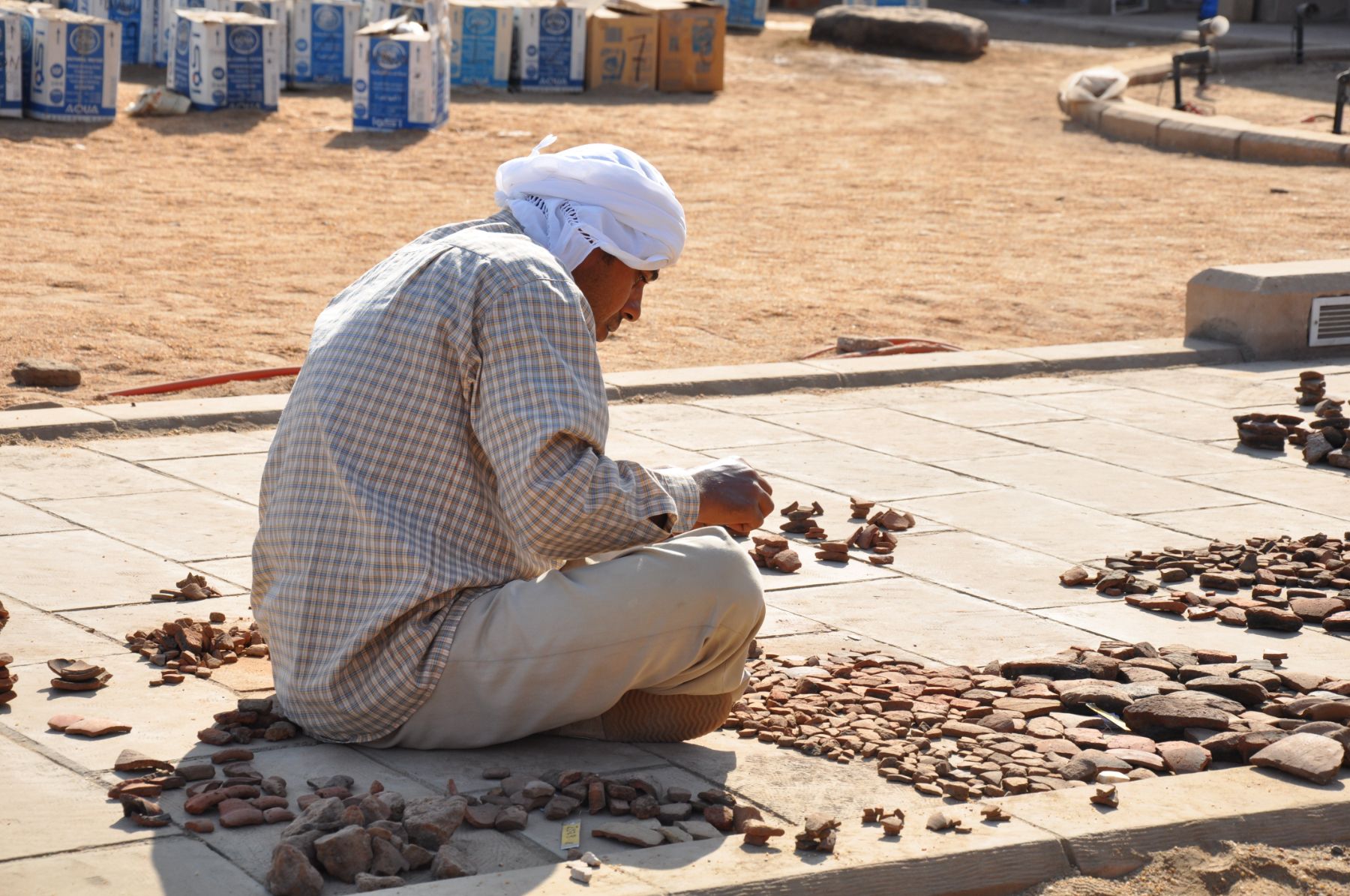 Local worker repairing stonework at an ancient temple site in Egypt