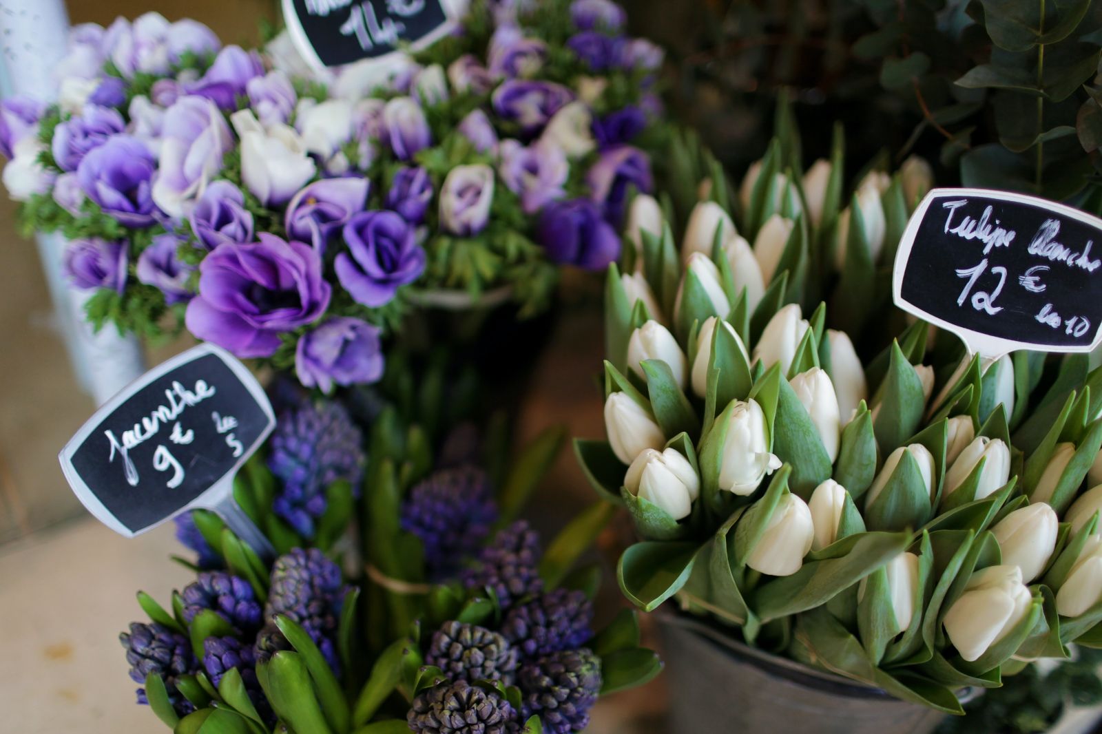 Bunches of white tulips hyacinths and purple blooms at a flower shop in France