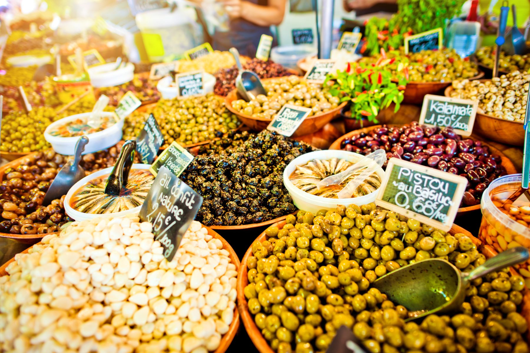 Large dishes of olives and garlic on display at a market stall in Provence