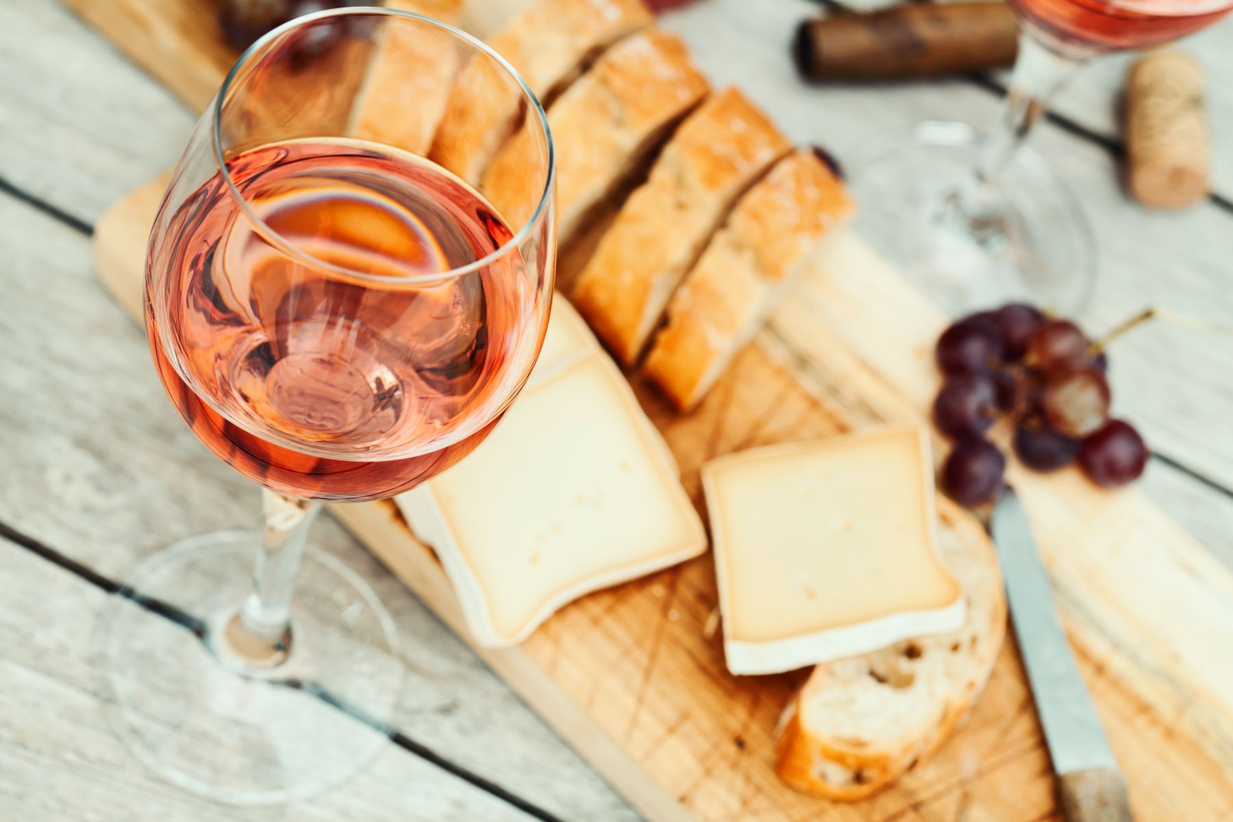 A cheeseboard with fresh bread, grapes and wine served in Provence