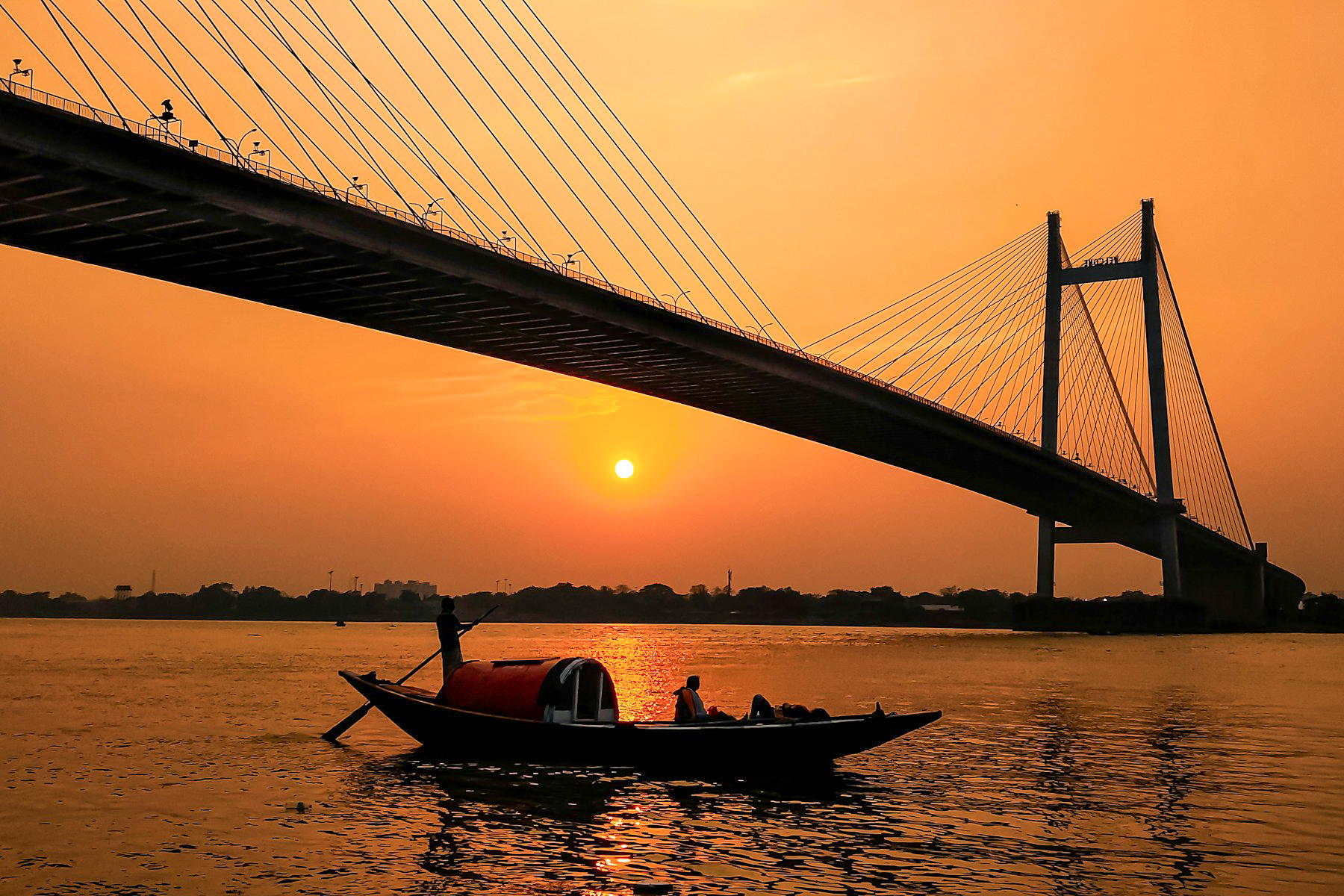 A boat sailing along the Hoogly in Kolkata at sunset