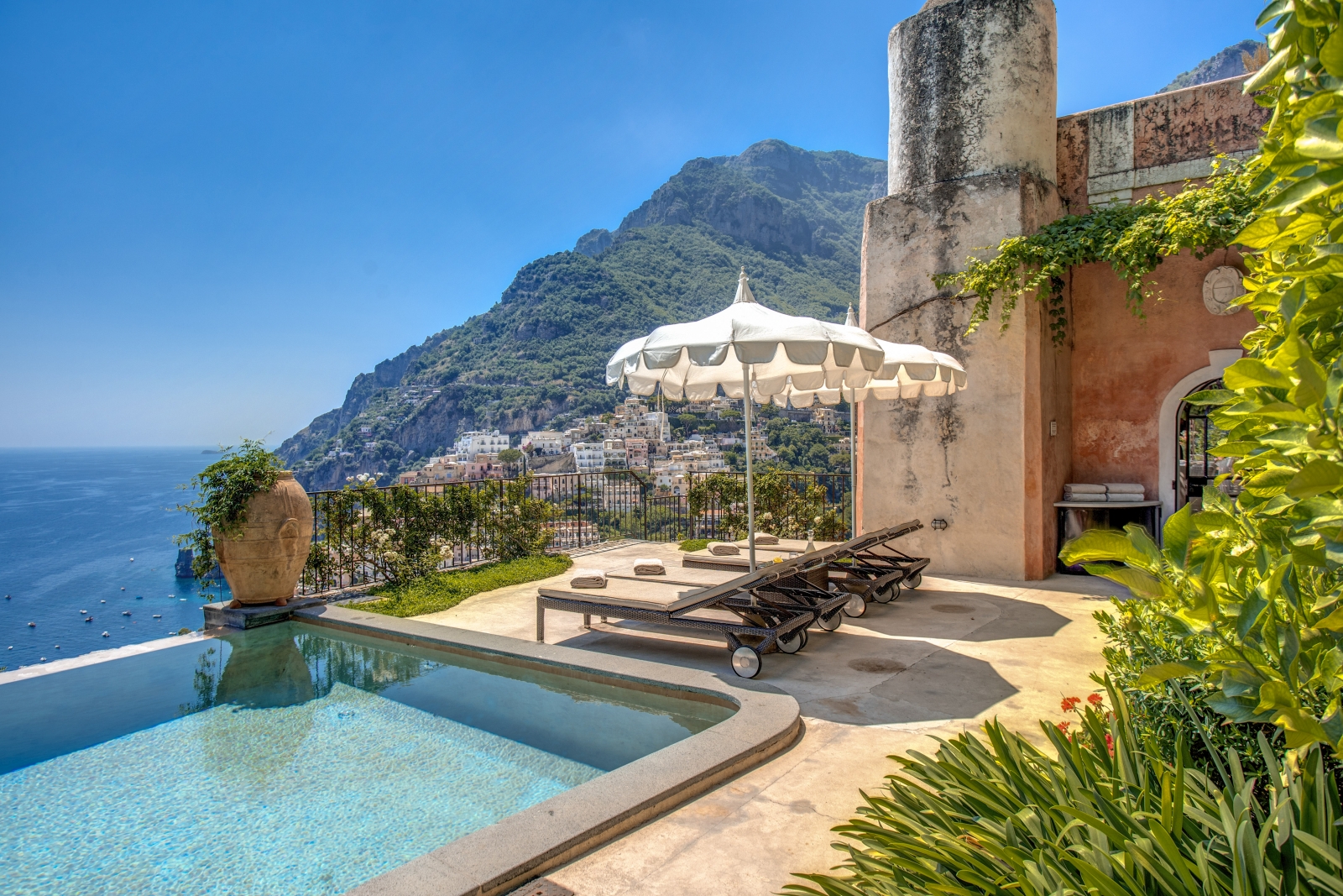 Sun loungers and umbrella on terrace with view in the background