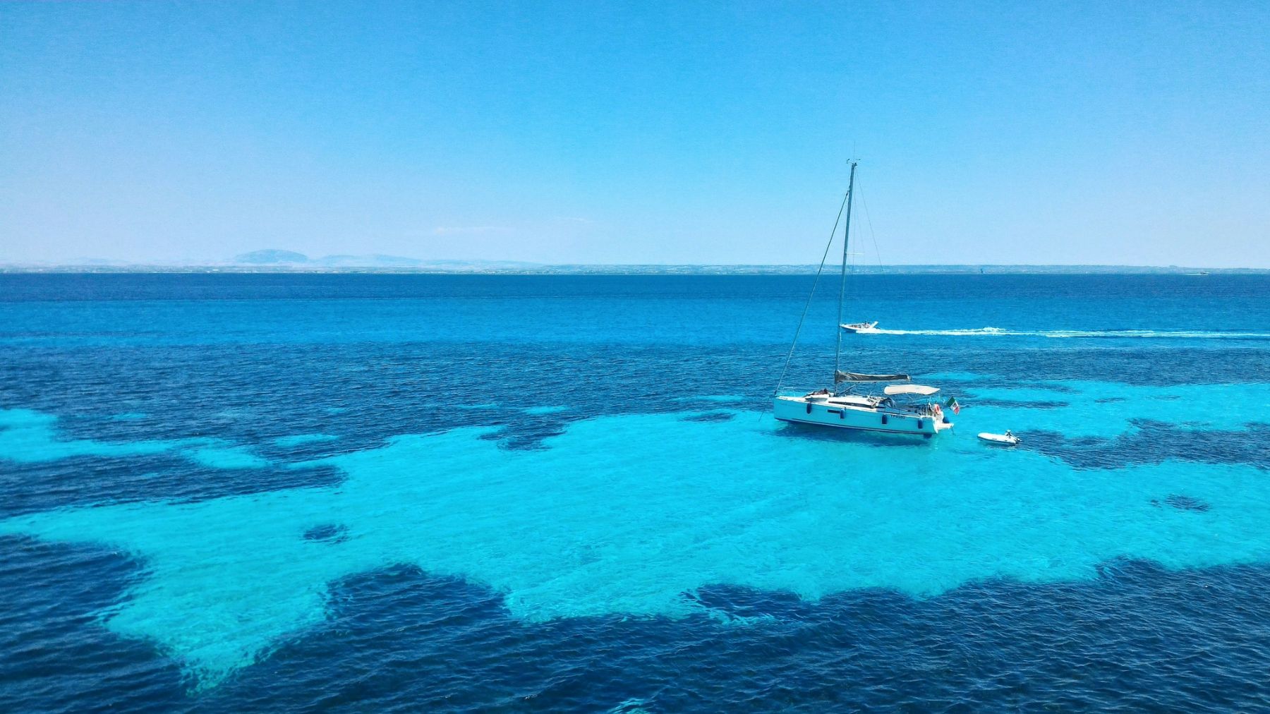 A yacht on the turquoise waters surrounding Sicily's Favignana Island 