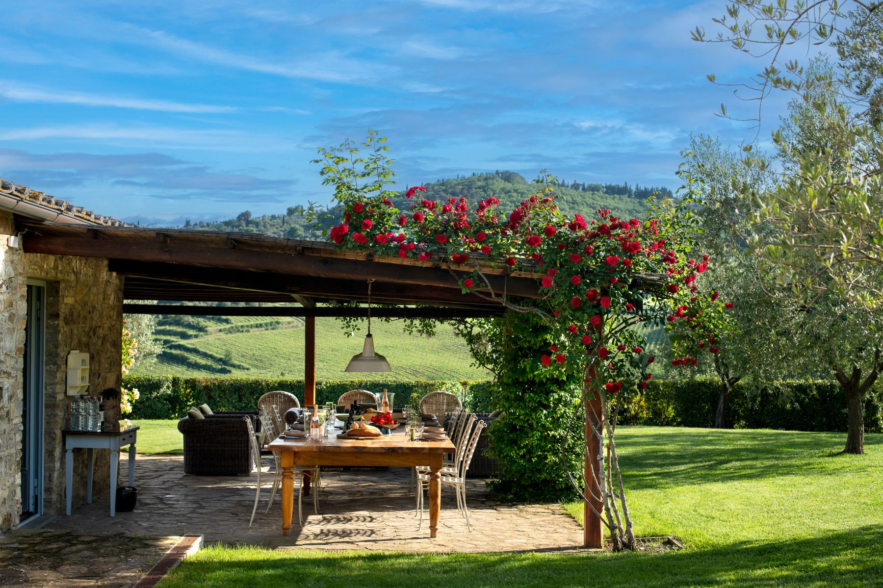 Outdoor dining area in the garden with views of Tuscan hills at Il Prato di Vignammagio