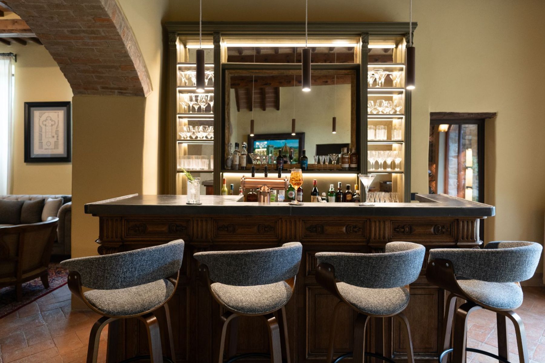 Bar area with four grey stools and a wooden bar surface at Villa Ardore in Tuscany