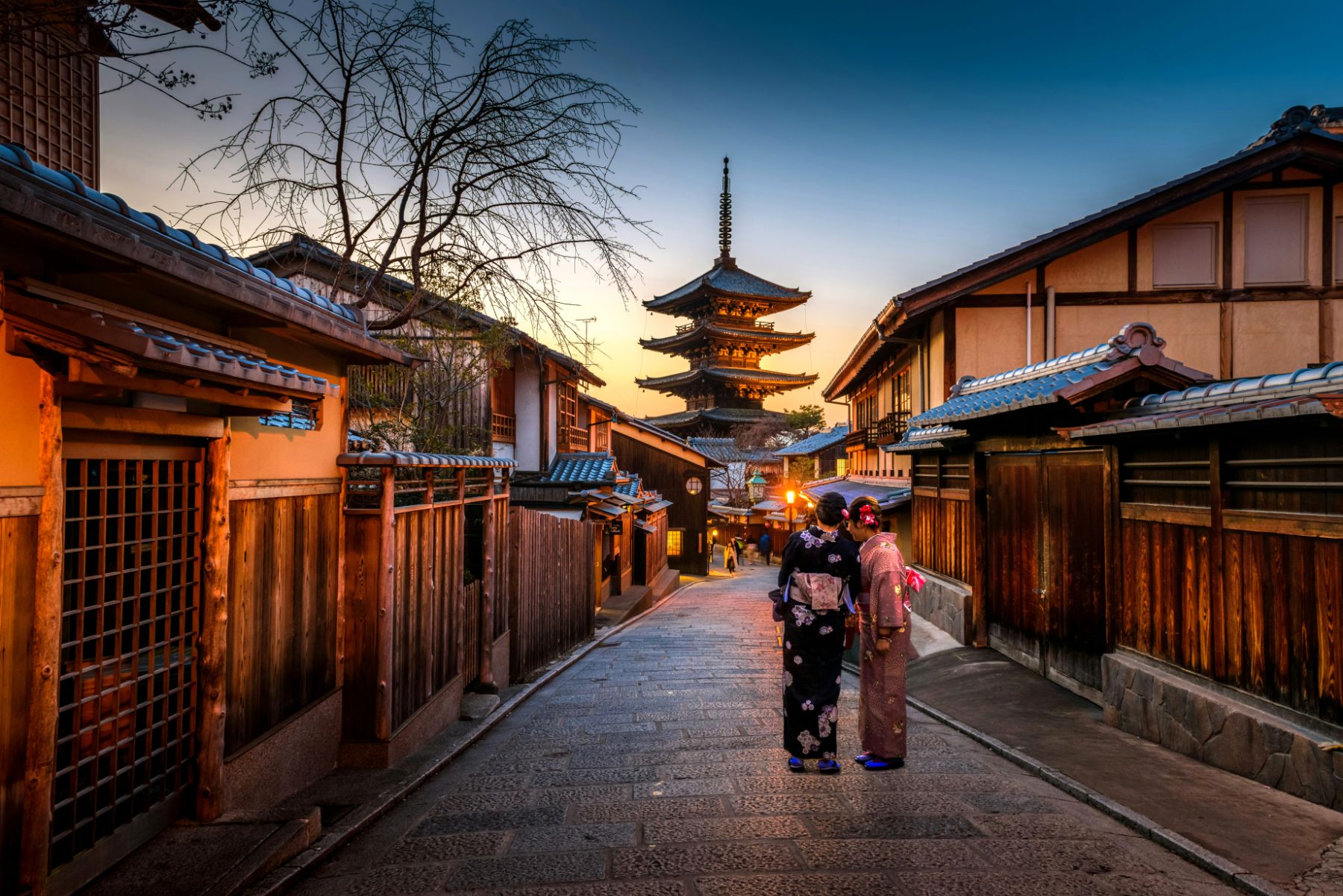 Two geishas on a Kyoto street at dusk in Japan