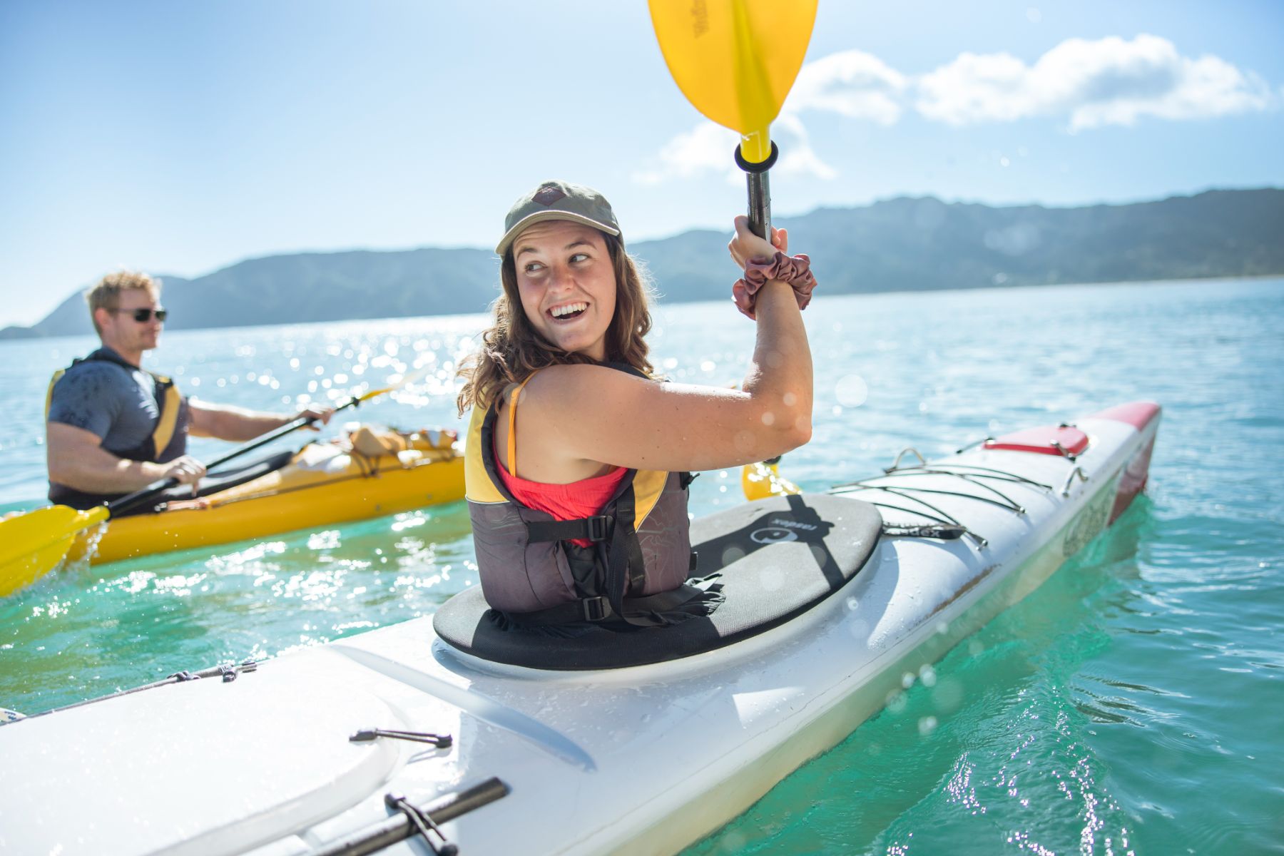 Young couple kayaking in clear waters in Abel Tasman New Zealand