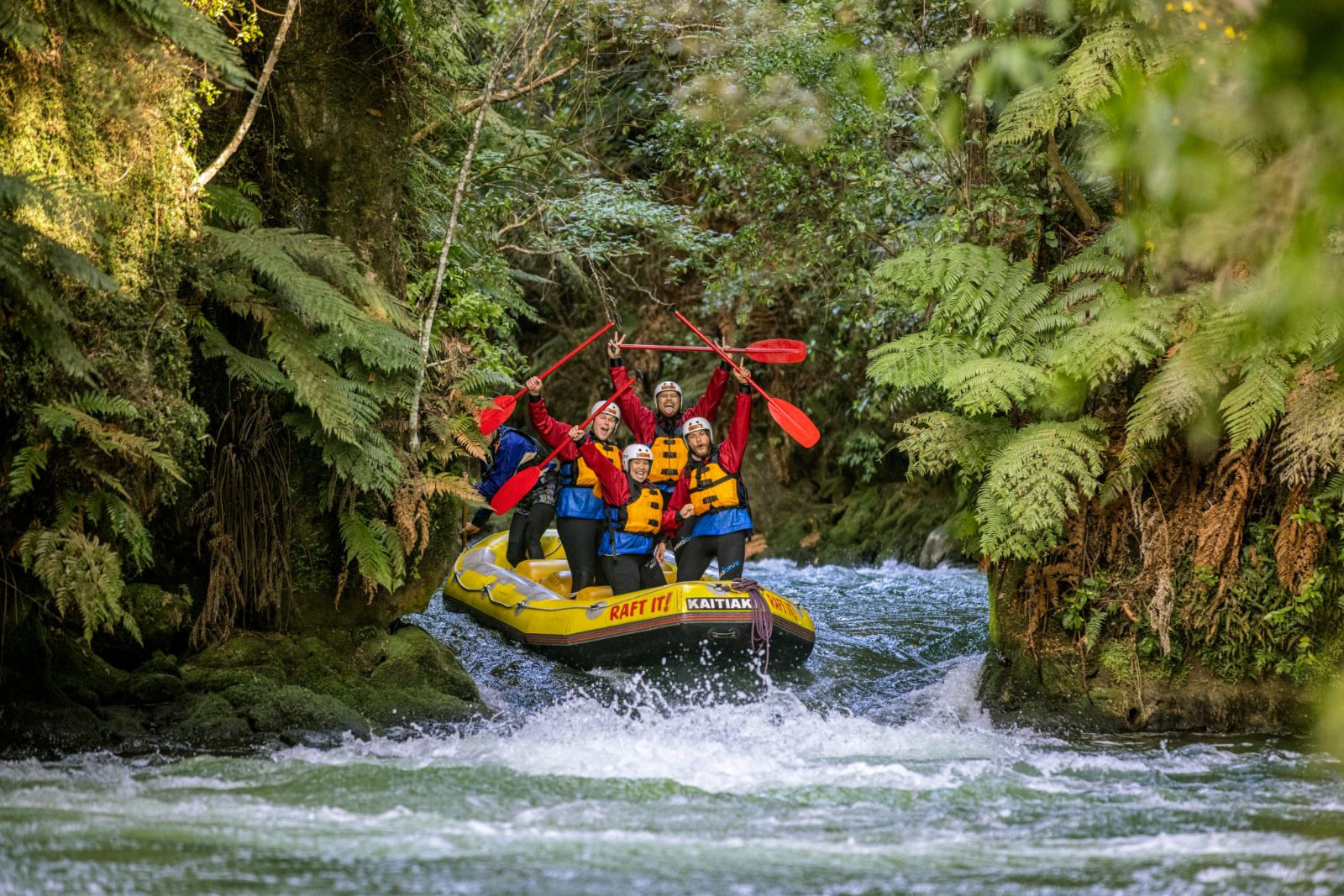 People enjoying white water rafting on the Kaitiki river near Rotorua New Zealand