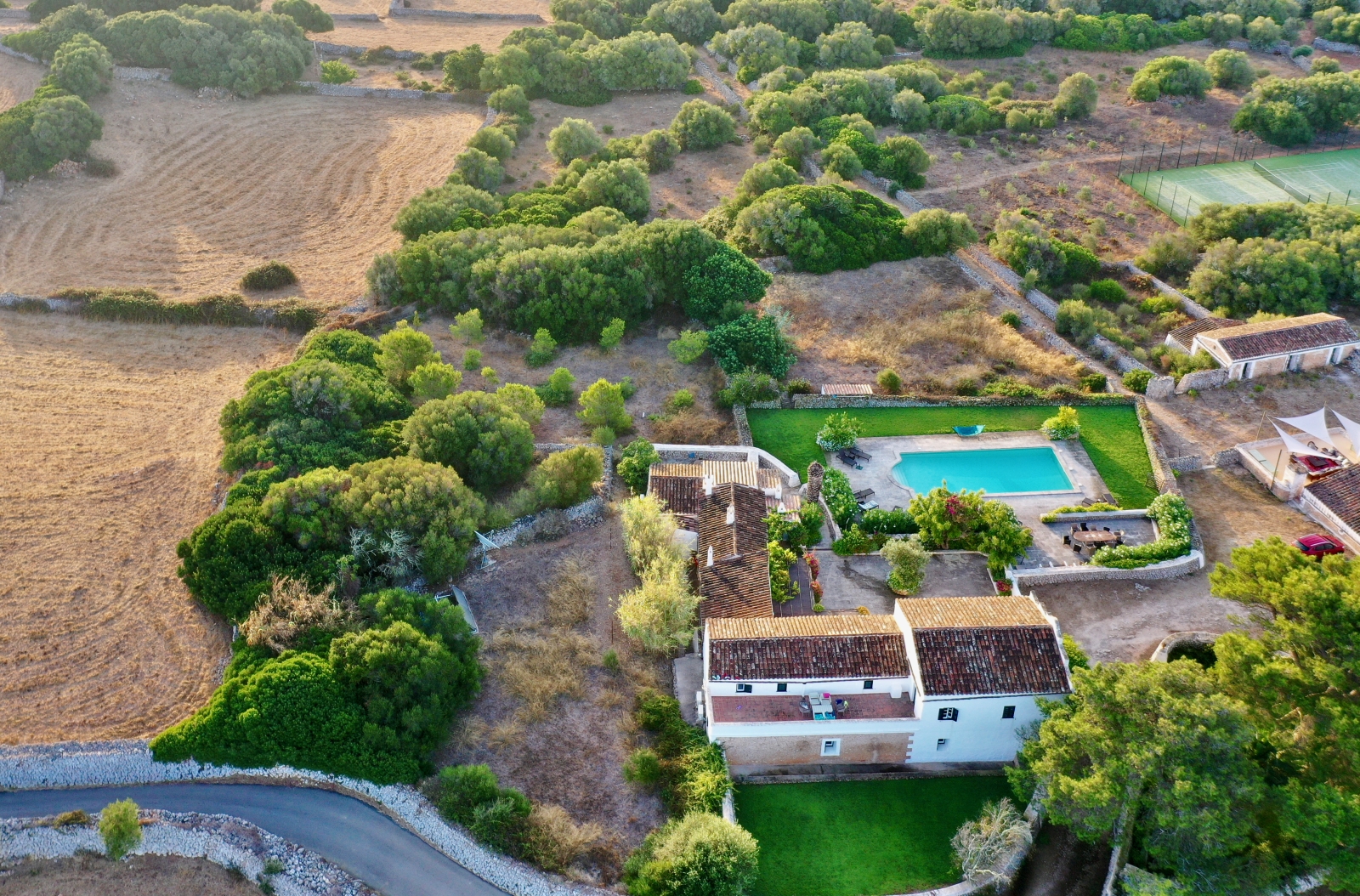 Aerial view of villa, pool, garden and tennis court at Finca Tortuga in Menorca, Spain