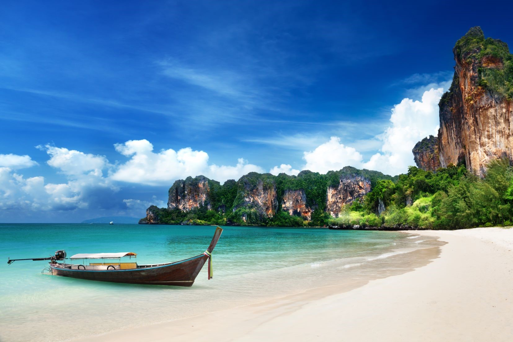 A traditional long-tail boat moored on the beaches of Krabi