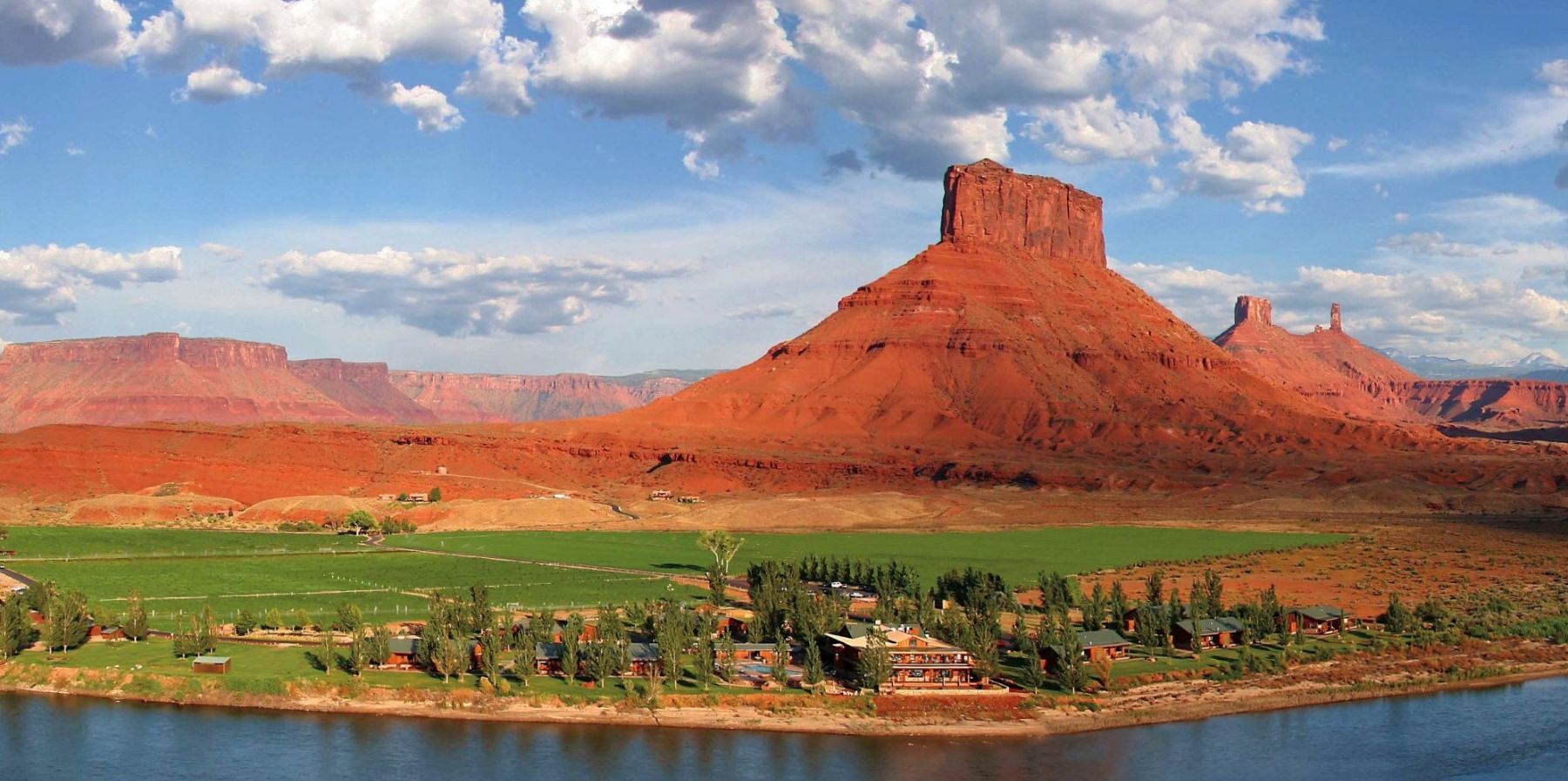 Distant view of Sorrel River Ranch in Utah and the red cliffs of Moab