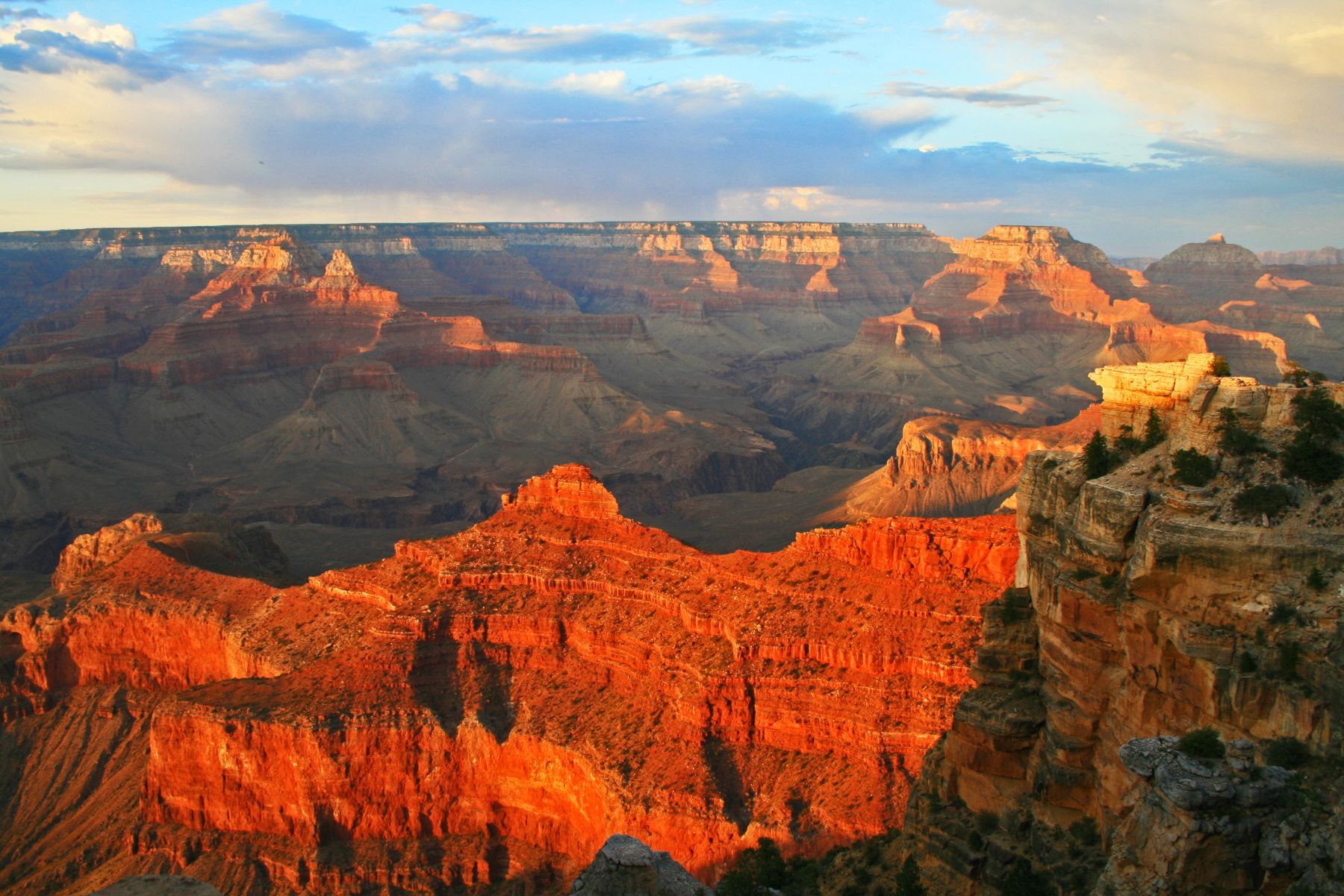 A cliff face of the Grand Canyon glowing red at sunset