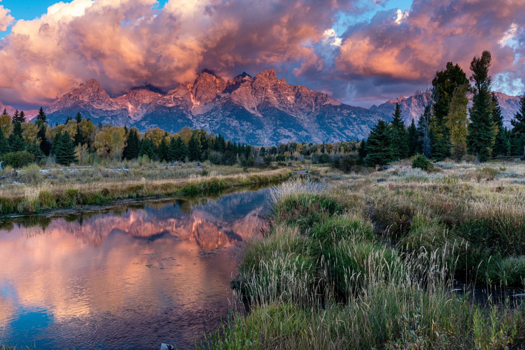 Dramatic mountains and clouds reflected in a river in the Grand Teton National Park USA