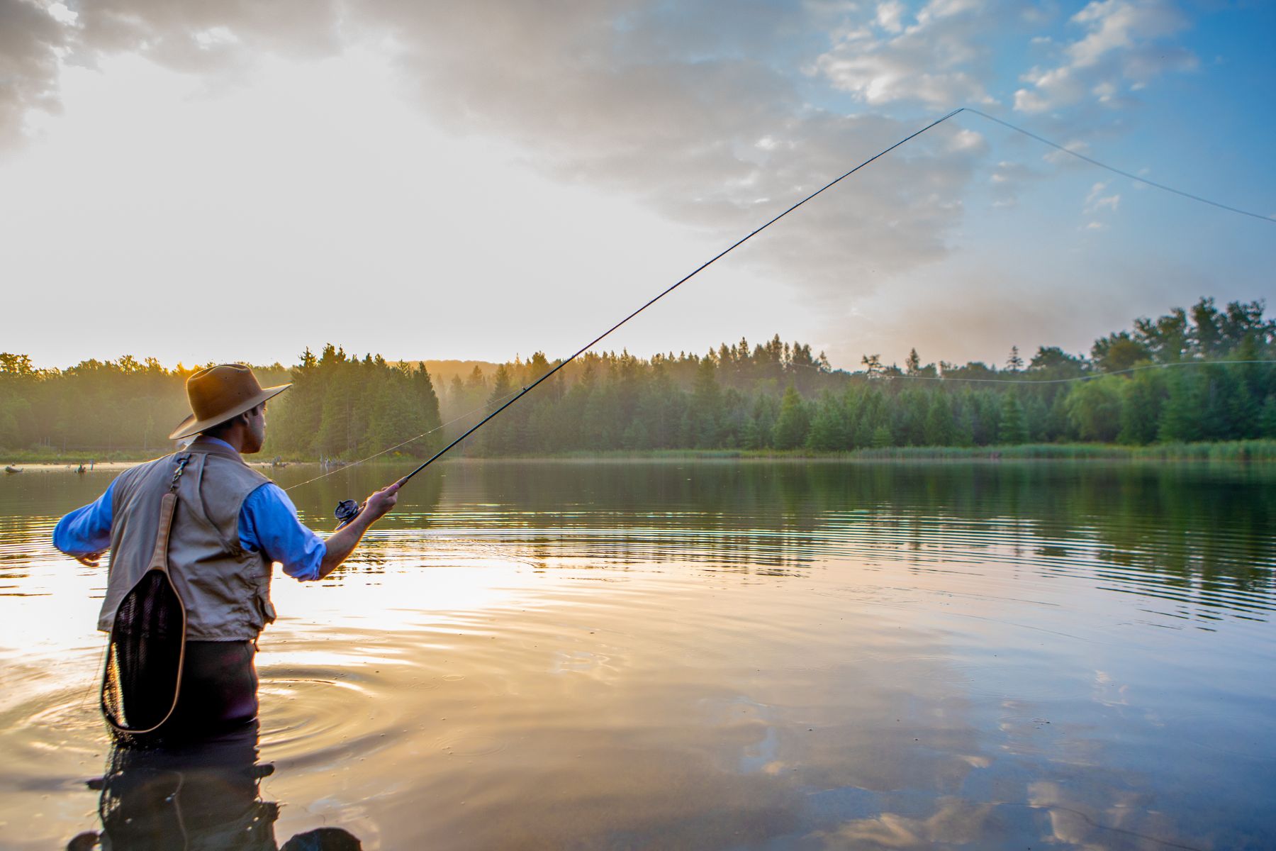 Man fly fishing in a large calm river