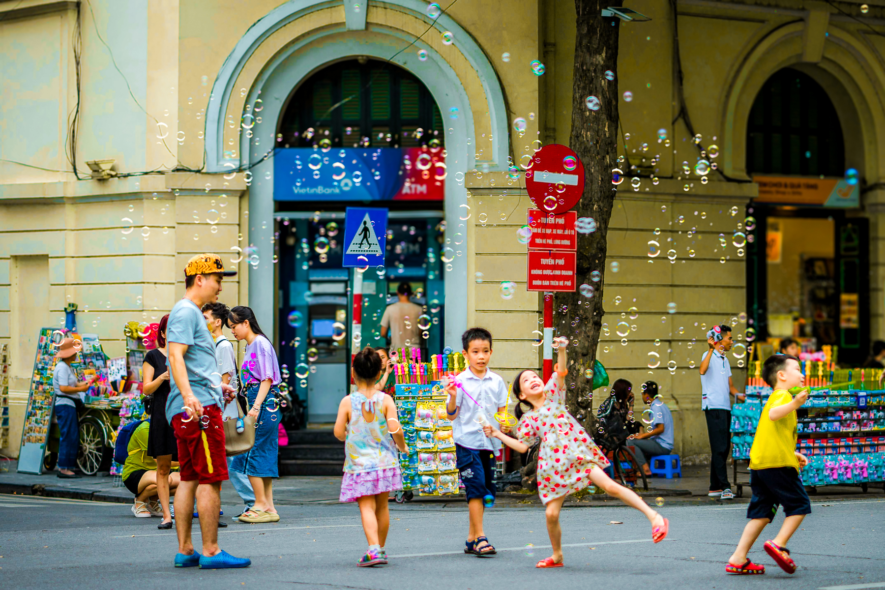 Children playing with bubbles in the streets of Hanoi