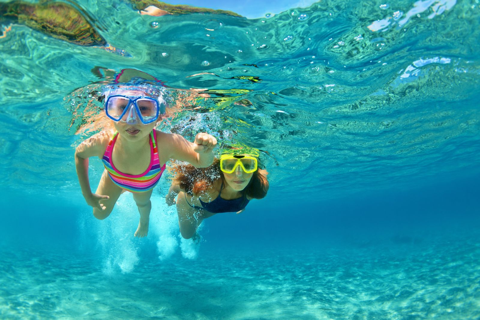 Mother and child snorkelling in crystal-clear waters