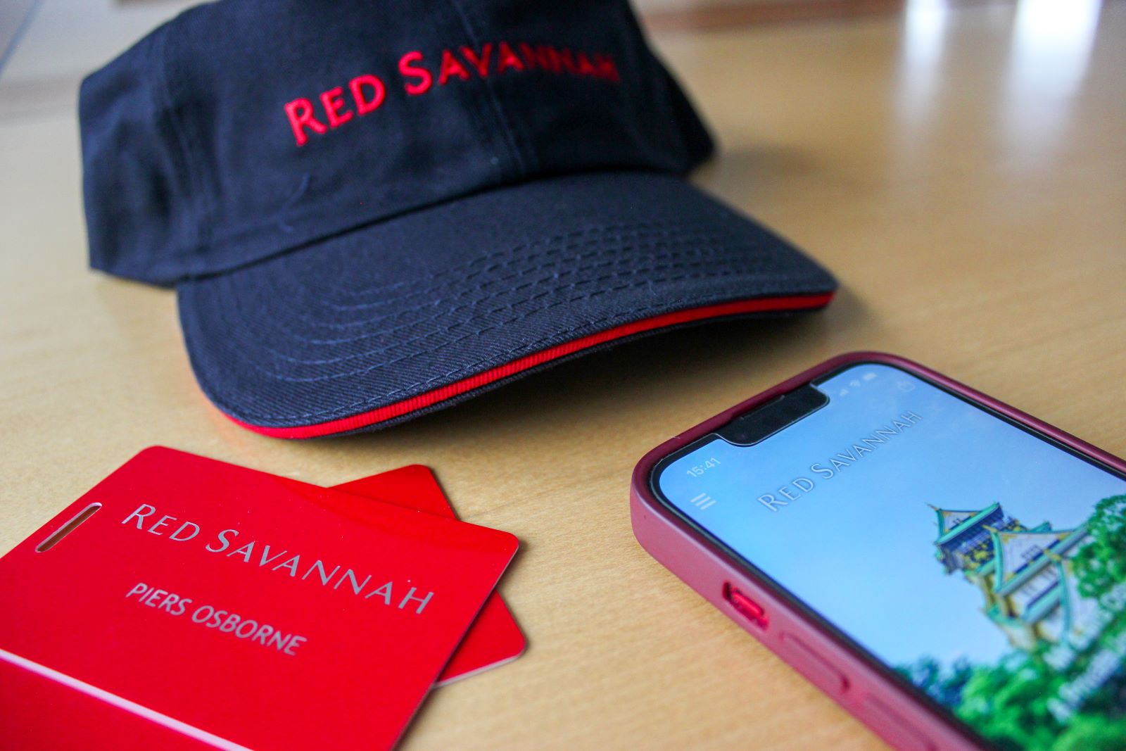 Red Savannah branded merchandise including a cap, luggage tags and Vamoos screen